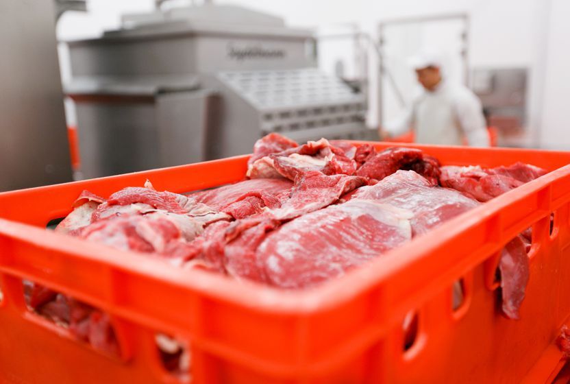 Kunststoffbehälter der Serie E für Fleisch, das in einem Schlachthof mit Waren gefüllt wird.